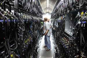 Image of a data centre serveer room showing a vast network of cable connections